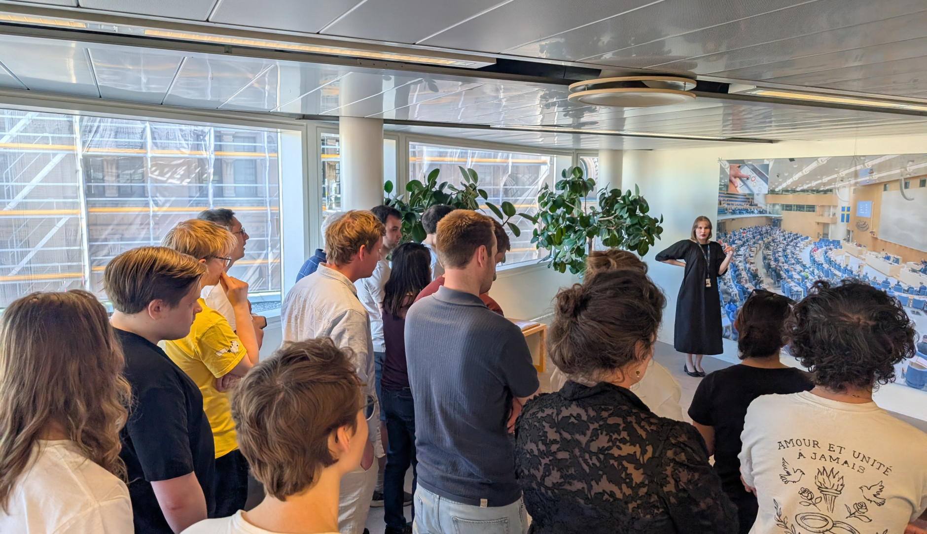 Several tourists & Volt members watching a guided Riksdag tour