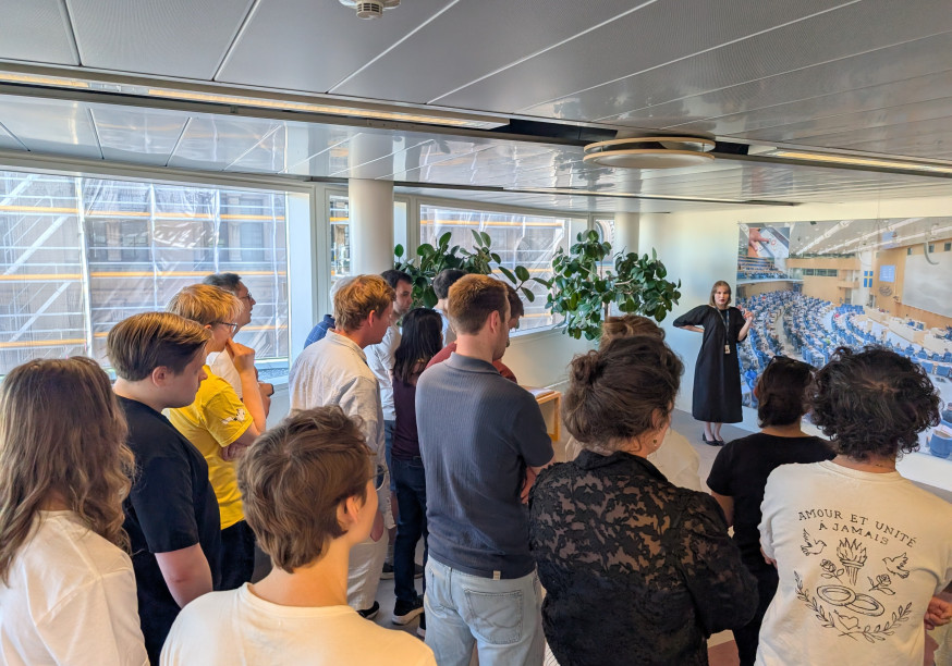 Several tourists & Volt members watching a guided Riksdag tour
