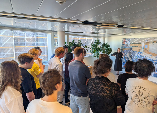 Several tourists & Volt members watching a guided Riksdag tour