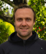 Portrait of Moritz Lang with greenery in the background