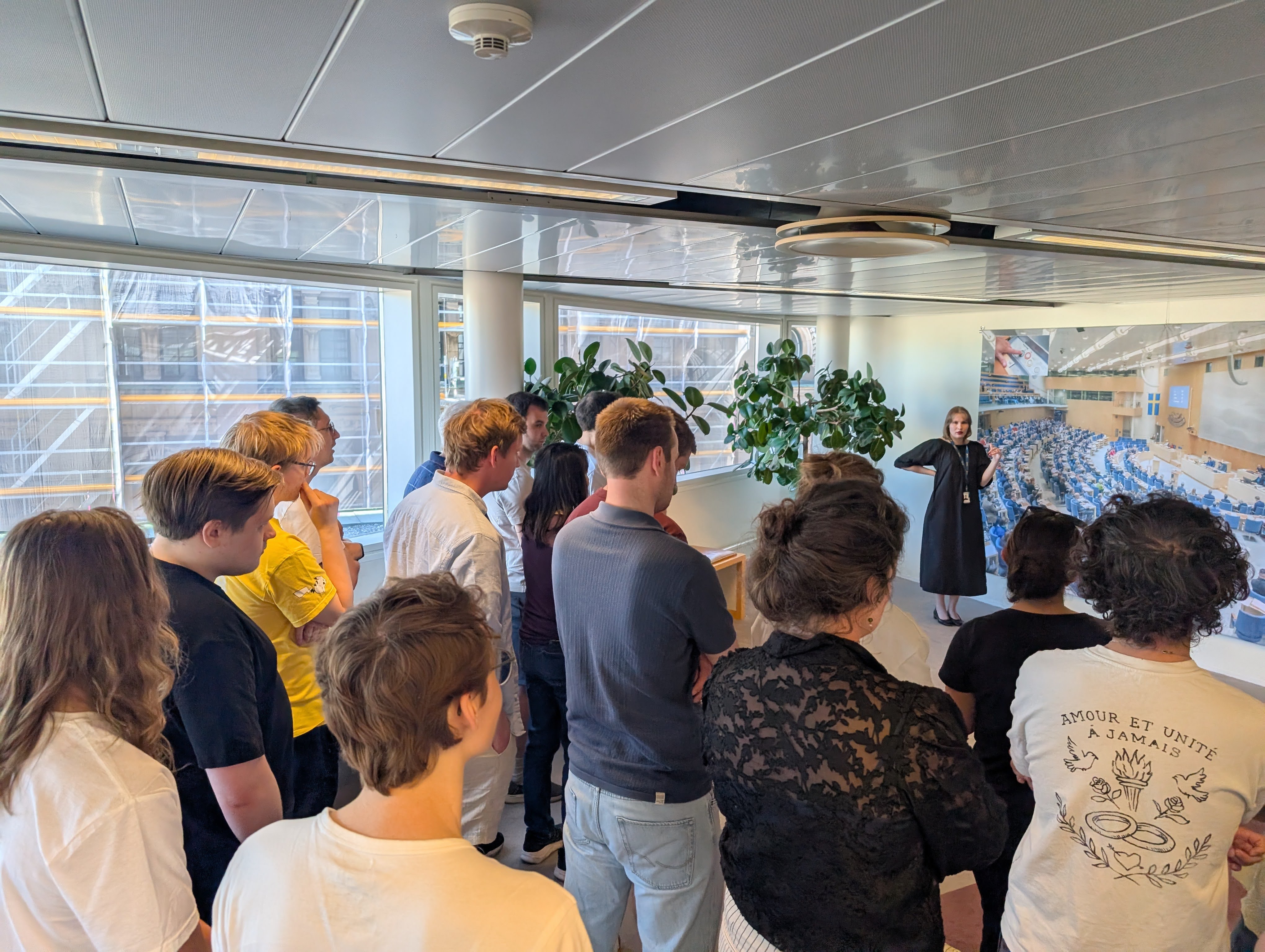 Several tourists & Volt members watching a guided Riksdag tour